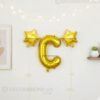 Golden foil balloon combo featuring letter 'C' (16 inch) and two star-shaped balloons (9 inch) for party decoration