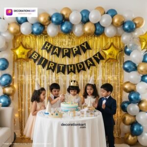 Birthday party setup with DECORATIONkart’s 66 pcs decoration kit featuring a black cardstock “Happy Birthday” banner, golden fringe curtains, metallic balloons in golden, blue, and white, golden star foils, and DIY accessories.