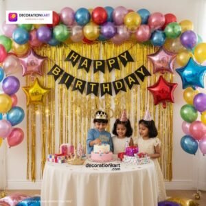 Birthday party setup with DECORATIONkart’s 66 pcs decoration kit featuring a black cardstock “Happy Birthday” banner, golden fringe curtains, multicolor metallic balloons, star foils in red, blue, golden, and pink, and DIY accessories.