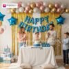 Indian children celebrating a birthday party with DECORATIONkart’s 66 pcs decoration combo set, featuring a blue dotted foil “Happy Birthday” banner, golden fringe curtains, metallic balloons in gold, pink, and white, blue star foil balloons, and DIY accessories.