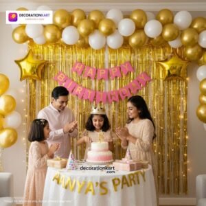 Birthday party setup with DECORATIONkart’s 66 pcs decoration kit featuring a pink cardstock “Happy Birthday” banner, golden fringe curtains, metallic balloons in golden, yellow, and white, golden star foils, and DIY accessories.