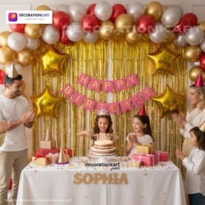 Birthday party setup with DECORATIONkart’s 66 pcs decoration kit featuring a pink cardstock “Happy Birthday” banner, golden fringe curtains, metallic balloons in golden, red, and white, golden star foils, and DIY accessories.