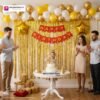 Birthday party setup with DECORATIONkart’s 66 pcs decoration kit featuring a red cardstock “Happy Birthday” banner, golden fringe curtains, metallic balloons in golden, yellow, and white, golden star foils, and DIY accessories.