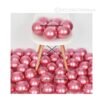 Glossy pink chrome latex balloons floating in a dreamy party setup with floral accents and soft lighting.