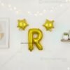 Golden foil balloon combo featuring letter 'R' (16 inch) and two star-shaped balloons (9 inch) for party decoration