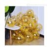 Transparent latex balloons filled with shiny golden confetti, floating in a festive party setup.