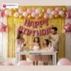 Indian children celebrating a birthday party with DECORATIONkart’s 66 pcs decoration combo set, featuring a pink foil “Happy Birthday” banner, golden fringe curtains, metallic balloons in gold, pink, and white, multicolor star foil balloons, and DIY accessories.