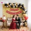 Anniversary party setup with DECORATIONkart’s 69 pcs decoration kit featuring a red cardstock “Happy Anniversary” banner, golden fringe curtains, metallic balloons in golden, black, and silver, golden and red heart foils, and DIY accessories.