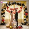 Anniversary party setup with DECORATIONkart’s 69 pcs decoration kit featuring a red foil “Happy Anniversary” banner, golden fringe curtains, metallic balloons in golden, black, and silver, golden and red heart foils, and DIY accessories.